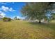 Spacious backyard with a large grassy area and mature trees at 16161 Juarez Cir, Punta Gorda, FL 33955