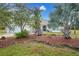 Landscaped front yard with mature palm trees and red mulch at 16161 Juarez Cir, Punta Gorda, FL 33955