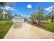 White house exterior with a spacious driveway and palm trees at 16161 Juarez Cir, Punta Gorda, FL 33955