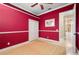 Red bedroom with a ceiling fan and access to hallway at 17557 Ohara Dr, Port Charlotte, FL 33948