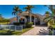 Luxury home with tile roof, palm trees, and a long driveway at 17557 Ohara Dr, Port Charlotte, FL 33948