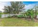 Landscaped backyard with tropical plants and a white fence at 1763 Oakland Rd, North Port, FL 34286