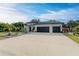 House exterior with a three-car garage and manicured lawn at 1763 Oakland Rd, North Port, FL 34286