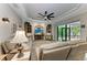 Comfortable living room featuring a large TV, built-in shelving, and ample natural light at 1763 Oakland Rd, North Port, FL 34286