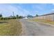 Long gravel driveway leading to a house with a detached garage at 18500 Ohara Dr, Port Charlotte, FL 33948