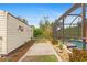 Landscaped backyard path leading to pool and shed at 201 Champion St, Port Charlotte, FL 33953