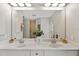 Double vanity bathroom with a large mirror reflecting the shower and window at 201 Champion St, Port Charlotte, FL 33953