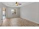 Bright bedroom with wood-look tile flooring, ceiling fan, and sliding door leading to the pool at 201 Champion St, Port Charlotte, FL 33953