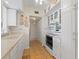 White kitchen with tiled floor, double sink, and glass cabinets at 217 W Tarpon Nw Blvd, Port Charlotte, FL 33952