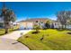 Yellow house with two-car garage and lush lawn at 24337 Contra Costa Ln, Punta Gorda, FL 33955