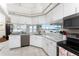 Modern kitchen with white cabinets, granite counters, and stainless steel appliances at 24337 Contra Costa Ln, Punta Gorda, FL 33955