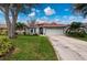 Single-story home with red tile roof, attached garage, and landscaped yard at 3191 Village Ln, Port Charlotte, FL 33953