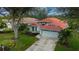 Single story home with tile roof, attached garage, and lush landscaping at 3191 Village Ln, Port Charlotte, FL 33953