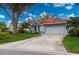 Single-story home with red tile roof, attached garage, and landscaped yard at 3191 Village Ln, Port Charlotte, FL 33953