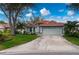 Single-story home with red tile roof, attached garage, and landscaped yard at 3191 Village Ln, Port Charlotte, FL 33953