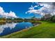 Serene pond view with a reflection of the sky and clouds at 3191 Village Ln, Port Charlotte, FL 33953