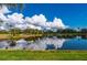 Stunning pond view reflecting fluffy clouds in a tranquil setting at 3191 Village Ln, Port Charlotte, FL 33953