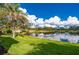 Scenic pond view with lush green grass and palm trees at 3191 Village Ln, Port Charlotte, FL 33953