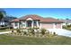 House exterior featuring a large, light-colored house with a tile roof, landscaping, and a three-car garage at 4037 Bal Harbor Blvd, Punta Gorda, FL 33950