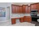 Kitchen features built-in desk, wood cabinets, and tile backsplash at 4037 Bal Harbor Blvd, Punta Gorda, FL 33950