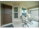 Covered front porch with two chairs and a view of the front yard at 6104 Plamendon Ave, North Port, FL 34291