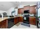 Modern kitchen with dark wood cabinets, stainless steel appliances, and ample counter space at 6104 Plamendon Ave, North Port, FL 34291