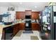 Modern kitchen with dark wood cabinets, stainless steel appliances, and ample counter space at 6104 Plamendon Ave, North Port, FL 34291