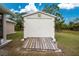 White storage shed with double doors and wooden platform at 6104 Plamendon Ave, North Port, FL 34291