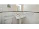 Clean bathroom with white tiled walls and pedestal sink at 6365 Scorpio Ave, North Port, FL 34287