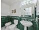 Bathroom with green tiled walls, pedestal sink, and toilet at 6365 Scorpio Ave, North Port, FL 34287