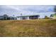 Back of house with screened patio and grassy yard at 6365 Scorpio Ave, North Port, FL 34287