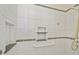Shower with white tiled walls and built-in shelves at 6365 Scorpio Ave, North Port, FL 34287