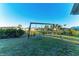 Swing set in grassy backyard with privacy fence and mature landscaping at 7342 N Ficus Tree, Punta Gorda, FL 33955