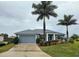 Single-story home with gray exterior, palm trees, and landscaped yard at 7342 N Ficus Tree, Punta Gorda, FL 33955