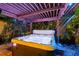 Relaxing hot tub under a wooden pergola with colorful lighting at 7424 S Moss Rose, Punta Gorda, FL 33955