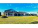 House back view with a large screened enclosure and grassy backyard at 108 Mccabe St, Port Charlotte, FL 33953