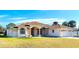 Single-story home with tile roof, fountain, and attached garage at 108 Mccabe St, Port Charlotte, FL 33953