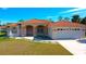 Single-story home with tile roof, fountain, and two-car garage at 108 Mccabe St, Port Charlotte, FL 33953