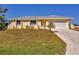 Bright yellow single-story house with gray roof, attached garage, and well-manicured lawn at 102 Annapolis Ln, Rotonda West, FL 33947