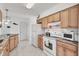 Kitchen with light wood cabinets, green granite counters, and white appliances at 102 Annapolis Ln, Rotonda West, FL 33947