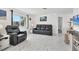 Living room featuring a leather sofa, recliner, and large windows at 102 Annapolis Ln, Rotonda West, FL 33947