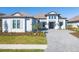 Two-story home with a gray tile roof, white walls, and a paver driveway at 10628 Nicklaus Ct, Englewood, FL 34223