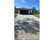 White house with gray paver driveway and dark garage door at 12547 Trinity Ave, Port Charlotte, FL 33953