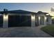 Modern home with dark garage door and paved driveway at 12547 Trinity Ave, Port Charlotte, FL 33953