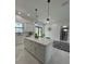 White kitchen island with breakfast bar and modern pendant lighting at 12547 Trinity Ave, Port Charlotte, FL 33953