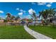 Landscaped backyard with walkway leading to a canal at 1380 Willet Ct, Punta Gorda, FL 33950