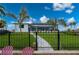 View of the home's backyard with a walkway and black fence at 1380 Willet Ct, Punta Gorda, FL 33950