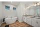 Elegant bathroom with a freestanding bathtub, double vanity, and granite countertop at 1380 Willet Ct, Punta Gorda, FL 33950