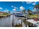 Private boat dock with lift and red chairs at 1380 Willet Ct, Punta Gorda, FL 33950