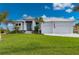 Modern home with a metal roof, landscaping, and two-car garage at 1380 Willet Ct, Punta Gorda, FL 33950